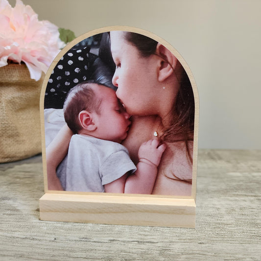 wood arched plaque with photo printed on it. It has a wood stand